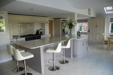 Inspiration for a large classic galley open plan kitchen in West Midlands with a submerged sink, recessed-panel cabinets, white cabinets, granite worktops, white splashback, stone slab splashback, stainless steel appliances, ceramic flooring, a breakfast bar, white floors and white worktops.