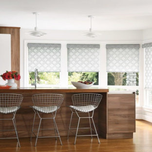 Mid-sized contemporary enclosed kitchen designs - Inspiration for a mid-sized contemporary l-shaped medium tone wood floor and brown floor enclosed kitchen remodel in San Diego with an undermount sink, flat-panel cabinets, white cabinets, solid surface countertops, white appliances, an island and white countertops