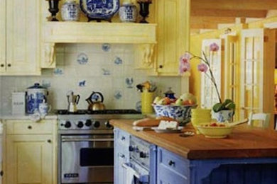 Kitchen - large traditional l-shaped medium tone wood floor kitchen idea in Philadelphia with raised-panel cabinets, yellow cabinets, wood countertops, white backsplash, porcelain backsplash, stainless steel appliances and an island