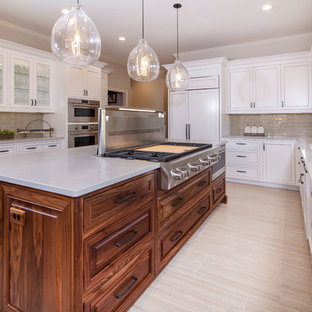 Inspiration for a large transitional u-shaped eat-in kitchen in Charlotte with beaded inset cabinets, white cabinets, solid surface benchtops, beige splashback, glass tile splashback, stainless steel appliances, ceramic floors, with island, beige floor and grey benchtop.