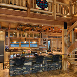 Photo of a mid-sized country u-shaped open plan kitchen in Other with an undermount sink, raised-panel cabinets, light wood cabinets, limestone benchtops, stainless steel appliances, light hardwood floors and with island.