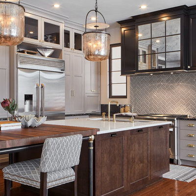 Inspiration for a mid-sized transitional l-shaped medium tone wood floor and brown floor kitchen remodel in Ottawa with an undermount sink, shaker cabinets, gray cabinets, granite countertops, stainless steel appliances, an island, gray backsplash and white countertops