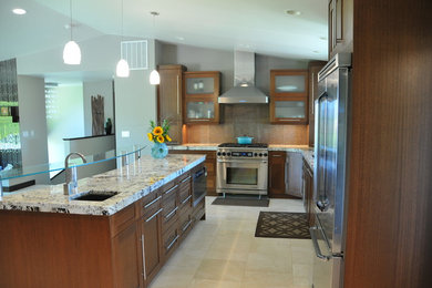Example of a large transitional l-shaped travertine floor eat-in kitchen design in Seattle with an undermount sink, glass-front cabinets, white cabinets, granite countertops, metallic backsplash, porcelain backsplash, stainless steel appliances and an island