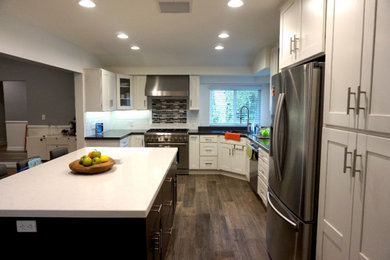 Inspiration for a timeless l-shaped medium tone wood floor and brown floor open concept kitchen remodel in Los Angeles with an undermount sink, recessed-panel cabinets, white cabinets, marble countertops, white backsplash, subway tile backsplash, stainless steel appliances, an island and gray countertops