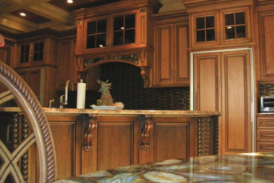 ニューヨークにあるラグジュアリーな広いトラディショナルスタイルのおしゃれなキッチン (ダブルシンク、インセット扉のキャビネット、中間色木目調キャビネット、御影石カウンター、茶色いキッチンパネル、ガラスタイルのキッチンパネル、シルバーの調理設備、トラバーチンの床) の写真