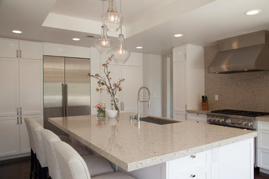 Eat-in kitchen - contemporary l-shaped medium tone wood floor eat-in kitchen idea in Los Angeles with an undermount sink, shaker cabinets, white cabinets, quartz countertops, beige backsplash, stone slab backsplash, stainless steel appliances and an island
