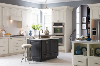 Example of a mid-sized trendy l-shaped marble floor and white floor enclosed kitchen design in Other with an undermount sink, raised-panel cabinets, white cabinets, granite countertops, white backsplash, subway tile backsplash, stainless steel appliances and an island