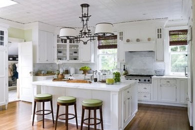 Inspiration for a large transitional l-shaped medium tone wood floor eat-in kitchen remodel in Miami with an undermount sink, recessed-panel cabinets, white cabinets, quartz countertops, gray backsplash, ceramic backsplash, paneled appliances and an island