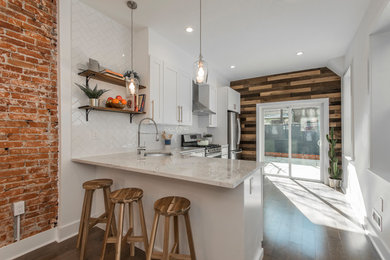 Mid-sized urban l-shaped dark wood floor and brown floor eat-in kitchen photo in Philadelphia with an undermount sink, shaker cabinets, white cabinets, granite countertops, white backsplash, ceramic backsplash, stainless steel appliances, a peninsula and white countertops