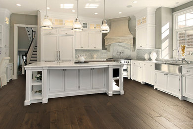 Eat-in kitchen - large transitional u-shaped dark wood floor eat-in kitchen idea in Toronto with a farmhouse sink, recessed-panel cabinets, white cabinets, marble countertops, white backsplash, stone slab backsplash, paneled appliances and an island