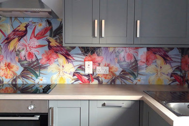 他の地域にあるコンテンポラリースタイルのおしゃれなキッチン (マルチカラーのキッチンパネル、ガラス板のキッチンパネル) の写真