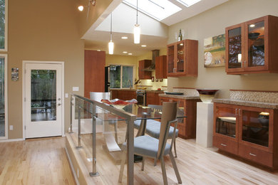 Kitchen - contemporary kitchen idea in Portland with glass-front cabinets and medium tone wood cabinets