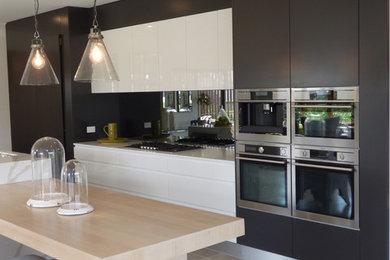 Imagen de cocina moderna de tamaño medio con armarios con paneles empotrados, puertas de armario negras, encimera de acrílico y una isla