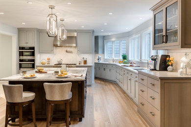 Inspiration for a large transitional l-shaped medium tone wood floor eat-in kitchen remodel in Boston with an undermount sink, flat-panel cabinets, gray cabinets, marble countertops and an island