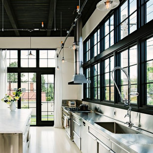 Inspiration for an industrial single-wall kitchen in Portland with an integrated sink, flat-panel cabinets, stainless steel cabinets, stainless steel benchtops, metallic splashback, metal splashback and stainless steel appliances.