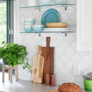 Idées déco pour une grand cuisine ouverte bord de mer en L avec un évier de ferme, un placard à porte shaker, des portes de placard jaunes, une crédence blanche, une crédence en carreau de céramique, un électroménager en acier inoxydable, un sol en bambou et 2 îlots.