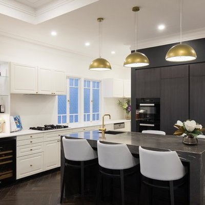 Example of a transitional l-shaped dark wood floor eat-in kitchen design in Brisbane with an undermount sink, flat-panel cabinets, black cabinets, black appliances and an island