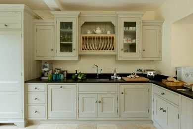 This is an example of a large country l-shaped open plan kitchen in Other with a submerged sink, shaker cabinets, green cabinets, granite worktops, ceramic flooring, no island and black worktops.