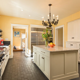 Esempio di una grande cucina chic chiusa con lavello stile country, ante in stile shaker, ante beige, elettrodomestici in acciaio inossidabile, pavimento in mattoni, pavimento nero e top in saponaria