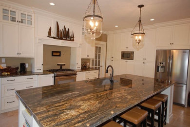 Example of a mid-sized transitional u-shaped vinyl floor eat-in kitchen design in Other with a drop-in sink, flat-panel cabinets, white cabinets, granite countertops, beige backsplash, colored appliances and an island