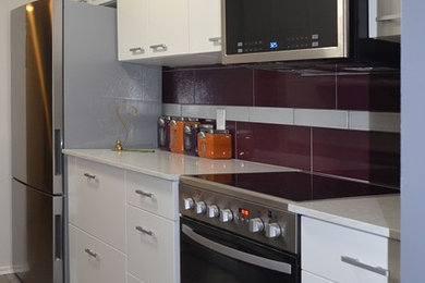 Example of a small trendy galley porcelain tile and gray floor enclosed kitchen design in Ottawa with a single-bowl sink, flat-panel cabinets, white cabinets, quartz countertops, multicolored backsplash, porcelain backsplash, stainless steel appliances, no island and white countertops