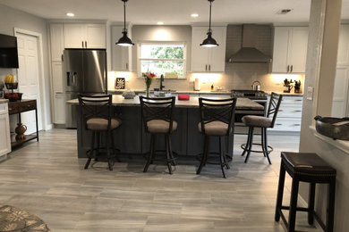 Inspiration for a large transitional porcelain tile and multicolored floor eat-in kitchen remodel in Sacramento with recessed-panel cabinets, white cabinets, an island, an undermount sink, ceramic backsplash and stainless steel appliances