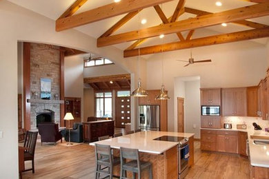 Example of a large mountain style l-shaped medium tone wood floor and brown floor eat-in kitchen design in Other with an undermount sink, shaker cabinets, medium tone wood cabinets, white backsplash, ceramic backsplash, stainless steel appliances and white countertops