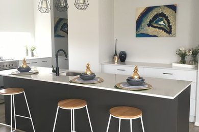 Zweizeilige, Große Moderne Wohnküche mit weißen Schränken, Granit-Arbeitsplatte und zwei Kücheninseln in Melbourne