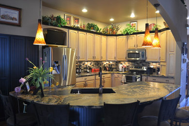 Inspiration for a timeless l-shaped eat-in kitchen remodel in Denver with an undermount sink, raised-panel cabinets, black cabinets and granite countertops