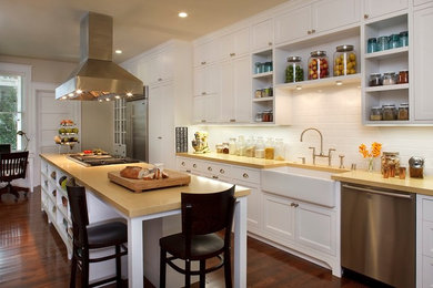Example of a mid-sized transitional single-wall dark wood floor and brown floor eat-in kitchen design in San Francisco with a farmhouse sink, recessed-panel cabinets, white cabinets, white backsplash, subway tile backsplash, stainless steel appliances, an island and wood countertops