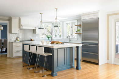 Inspiration for a modern brown floor kitchen remodel in Boston with white cabinets, white backsplash and an island