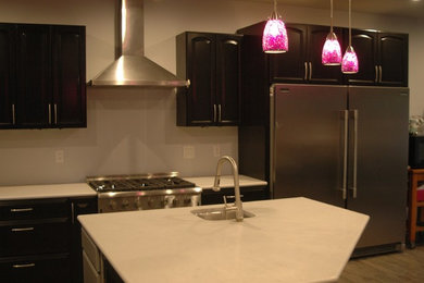 Imagen de cocina actual de tamaño medio con encimera de cuarzo compacto, electrodomésticos de acero inoxidable y una isla