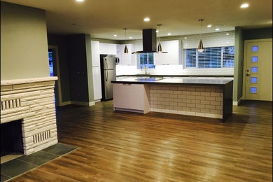 Example of a mid-sized minimalist l-shaped vinyl floor open concept kitchen design in Los Angeles with a single-bowl sink, flat-panel cabinets, white cabinets, quartz countertops, white backsplash, ceramic backsplash, stainless steel appliances and an island