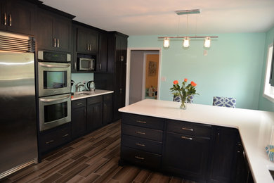 Inspiration for a mid-sized contemporary l-shaped dark wood floor enclosed kitchen remodel in Philadelphia with shaker cabinets, dark wood cabinets, marble countertops, stainless steel appliances, a peninsula and a double-bowl sink