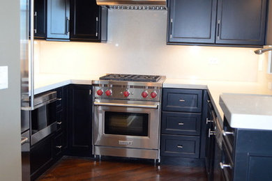 シカゴにあるコンテンポラリースタイルのおしゃれなキッチン (黒いキャビネット、珪岩カウンター、白いキッチンパネル、石スラブのキッチンパネル、シルバーの調理設備、濃色無垢フローリング) の写真