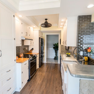 Idee per una cucina parallela chic di medie dimensioni con lavello stile country, ante con riquadro incassato, ante bianche, top in legno, paraspruzzi grigio, paraspruzzi con piastrelle di vetro, elettrodomestici in acciaio inossidabile, pavimento in legno massello medio, nessuna isola, pavimento marrone e top giallo