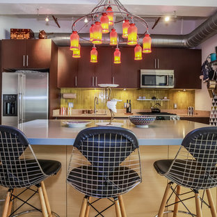 Eclectic kitchen in Los Angeles with an undermount sink, flat-panel cabinets, medium wood cabinets, zinc benchtops, green splashback, ceramic splashback, stainless steel appliances, concrete floors and with island.
