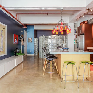 This is an example of an eclectic kitchen in Los Angeles with an undermount sink, flat-panel cabinets, medium wood cabinets, zinc benchtops, green splashback, ceramic splashback, stainless steel appliances, concrete floors and with island.
