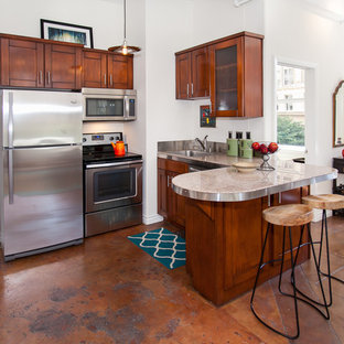 Small kitchen ideas - Example of a small u-shaped kitchen design in Los Angeles with dark wood cabinets, stainless steel appliances and a peninsula