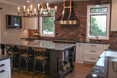 Eat-in kitchen - large country l-shaped medium tone wood floor and brown floor eat-in kitchen idea in Chicago with recessed-panel cabinets, white cabinets, granite countertops, multicolored backsplash, brick backsplash, black appliances and an island