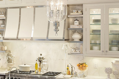Inspiration for a transitional l-shaped eat-in kitchen remodel in New York with an undermount sink, glass-front cabinets, marble countertops, white backsplash, stone slab backsplash and stainless steel appliances