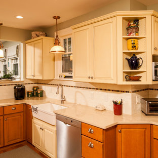 Inspiration for a country l-shaped eat-in kitchen in Detroit with white splashback, subway tile splashback, stainless steel appliances, a farmhouse sink, raised-panel cabinets, yellow cabinets, limestone benchtops, medium hardwood floors and a peninsula.