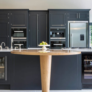 Design ideas for a traditional kitchen in Buckinghamshire with shaker cabinets, black cabinets, black appliances and an island.