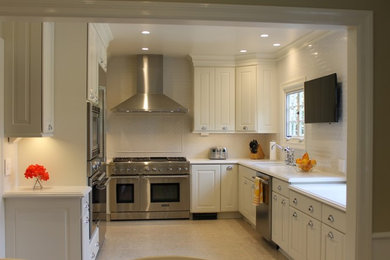 Eat-in kitchen - large transitional u-shaped cork floor and white floor eat-in kitchen idea in Los Angeles with a double-bowl sink, raised-panel cabinets, white cabinets, quartz countertops, white backsplash, ceramic backsplash, stainless steel appliances and no island