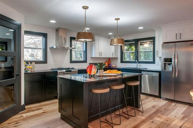 Inspiration for a large modern l-shaped eat-in kitchen remodel in Nashville with shaker cabinets, black cabinets, granite countertops, white backsplash, stainless steel appliances, an island and black countertops
