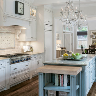 Traditional kitchen designs - Example of a classic dark wood floor and brown floor kitchen design in Chicago with recessed-panel cabinets, distressed cabinets, beige backsplash, subway tile backsplash, paneled appliances, two islands and gray countertops