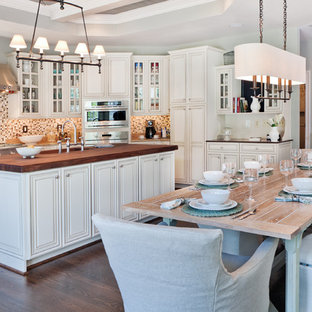 Imagen de cocina comedor clásica renovada con electrodomésticos de acero inoxidable y encimera de madera
