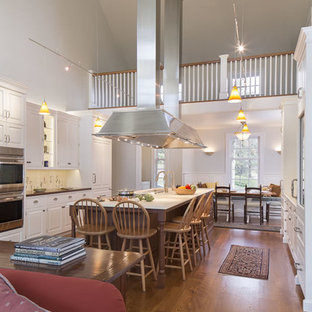 Huge traditional open concept kitchen photos - Open concept kitchen - huge traditional galley medium tone wood floor and brown floor open concept kitchen idea in Boston with raised-panel cabinets, white cabinets, stainless steel appliances, an island, multicolored backsplash, an undermount sink, limestone countertops and porcelain backsplash