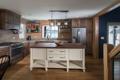 Inspiration for a rustic medium tone wood floor and brown floor eat-in kitchen remodel in New York with a drop-in sink, recessed-panel cabinets, white cabinets, quartz countertops, ceramic backsplash, stainless steel appliances, an island and multicolored backsplash