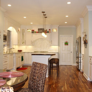 Large traditional eat-in kitchen pictures - Example of a large classic u-shaped dark wood floor eat-in kitchen design in Other with an undermount sink, white cabinets, quartzite countertops, white backsplash, stainless steel appliances and an island